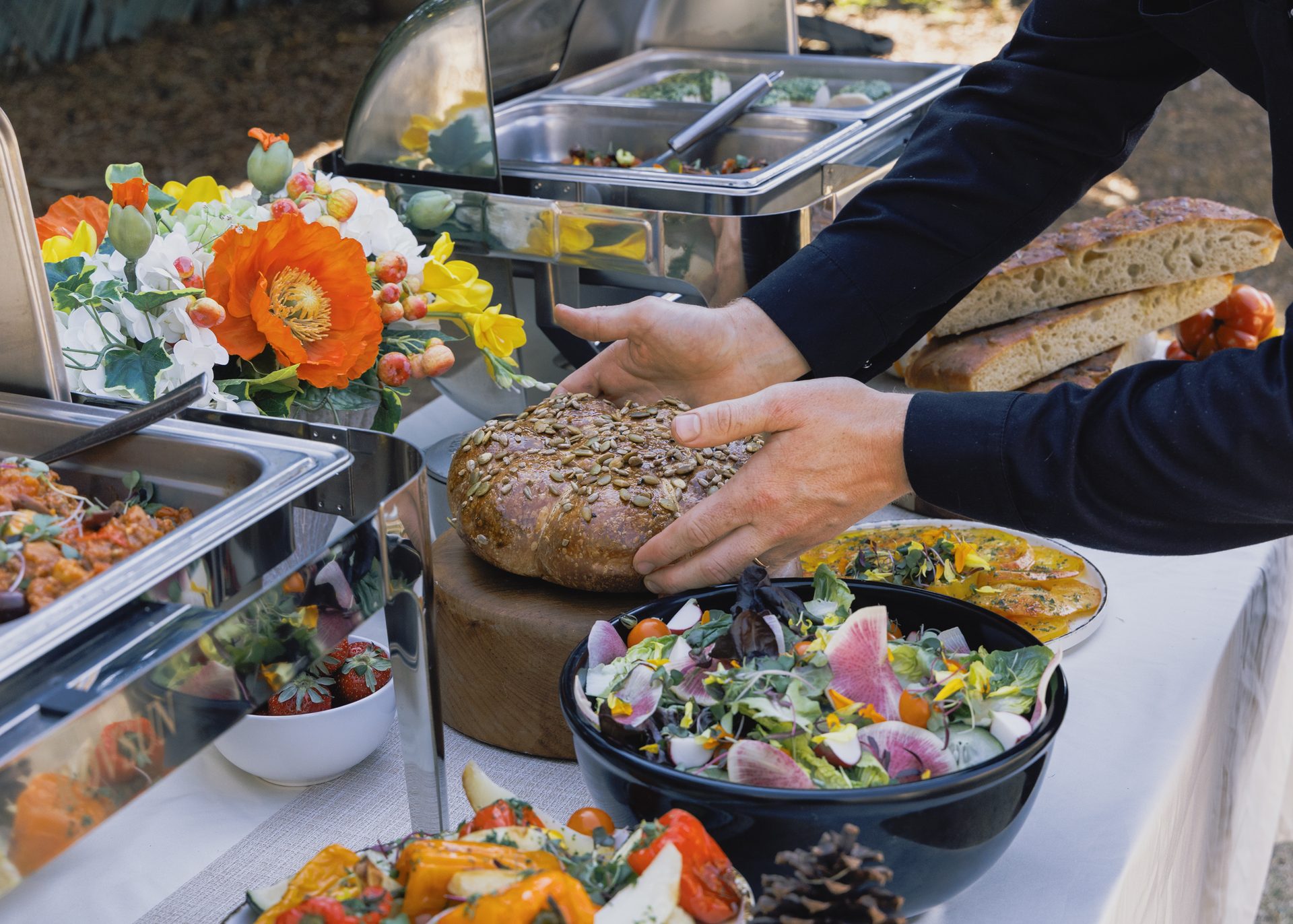 A buffet of salads, breads and seasonal dishes being finished