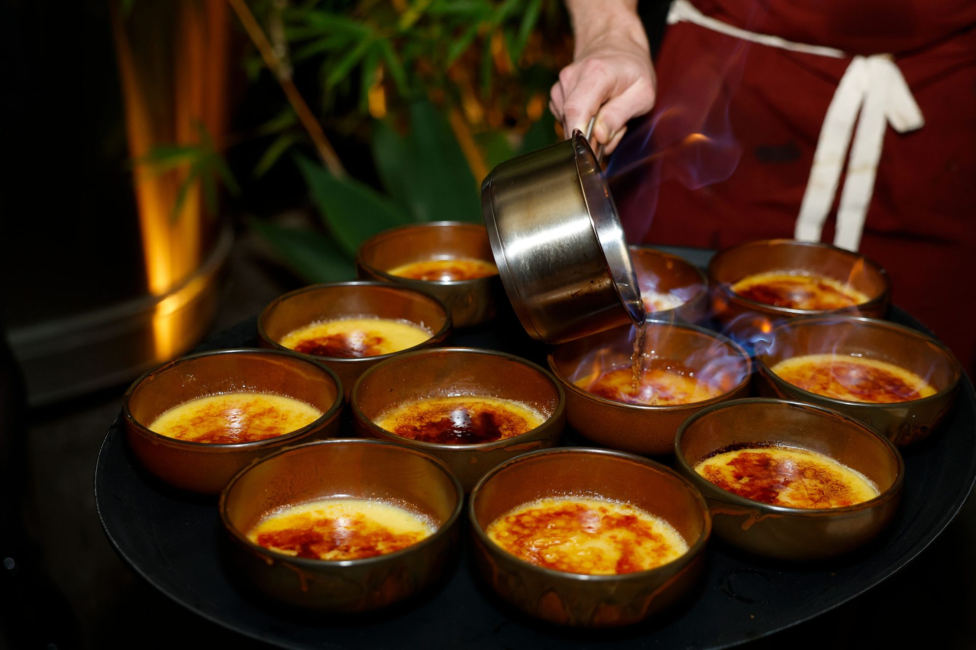 Individual custards being finished in copper dishes