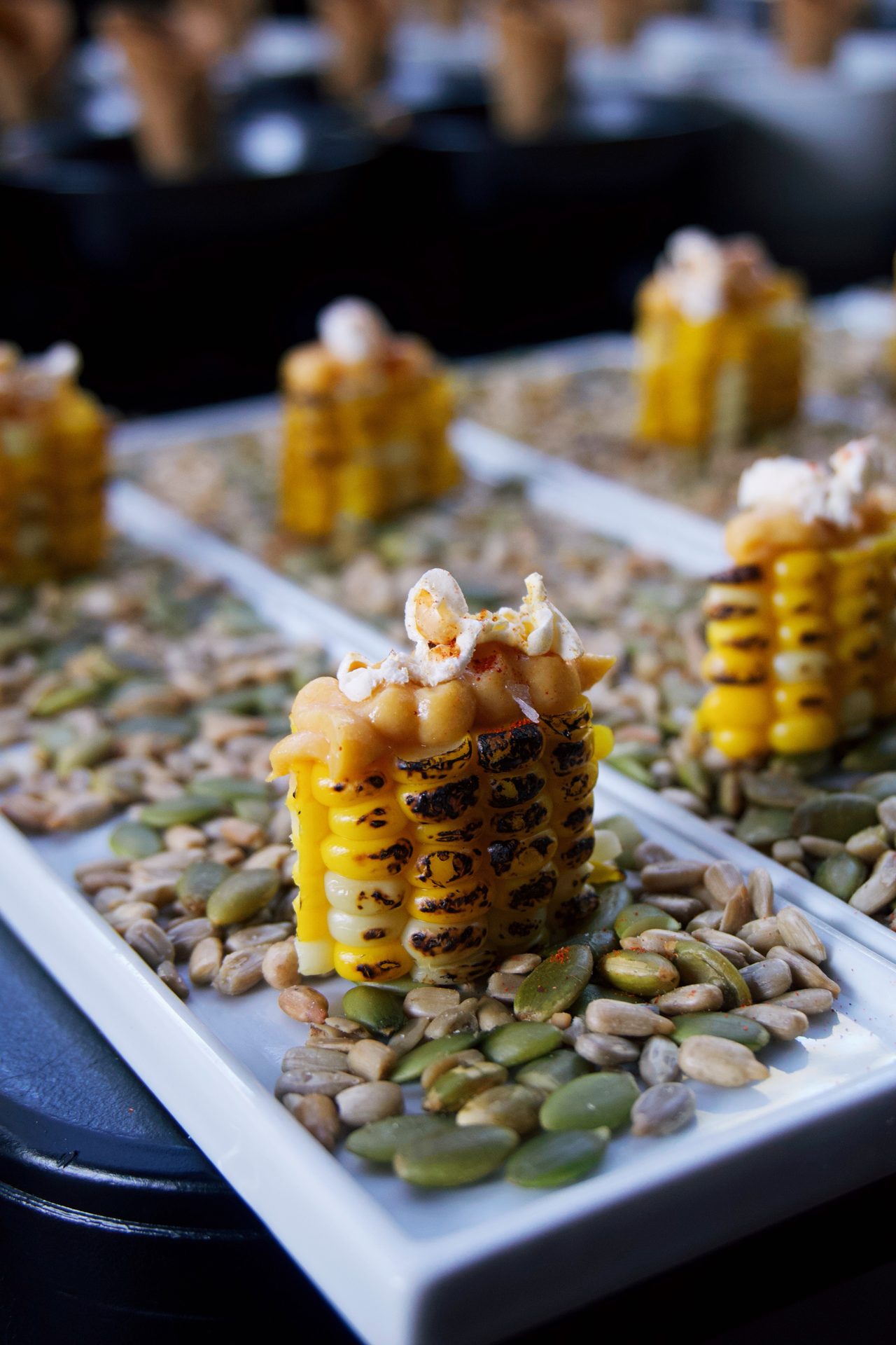 Grilled corn plated on a long ceramic tray