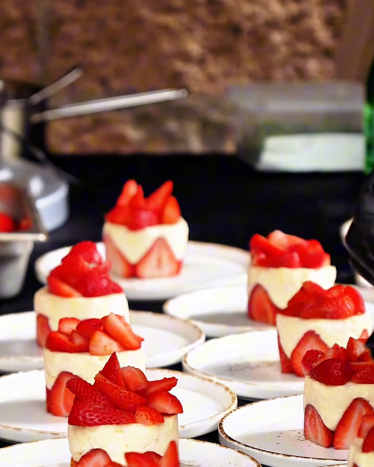 A row of strawberry desserts plated for service at a pop-up event