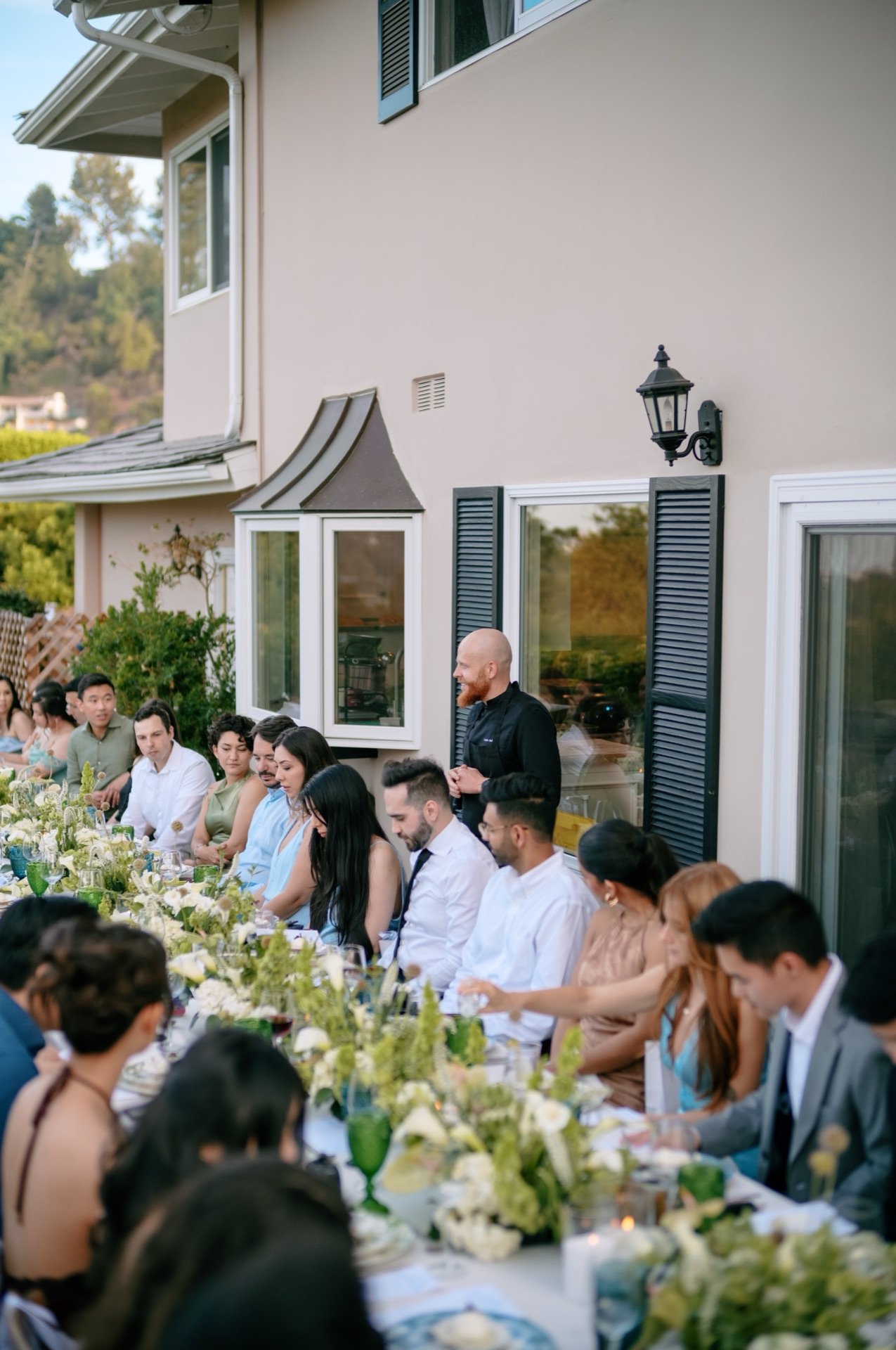 Guests seated at a long outdoor table during an event