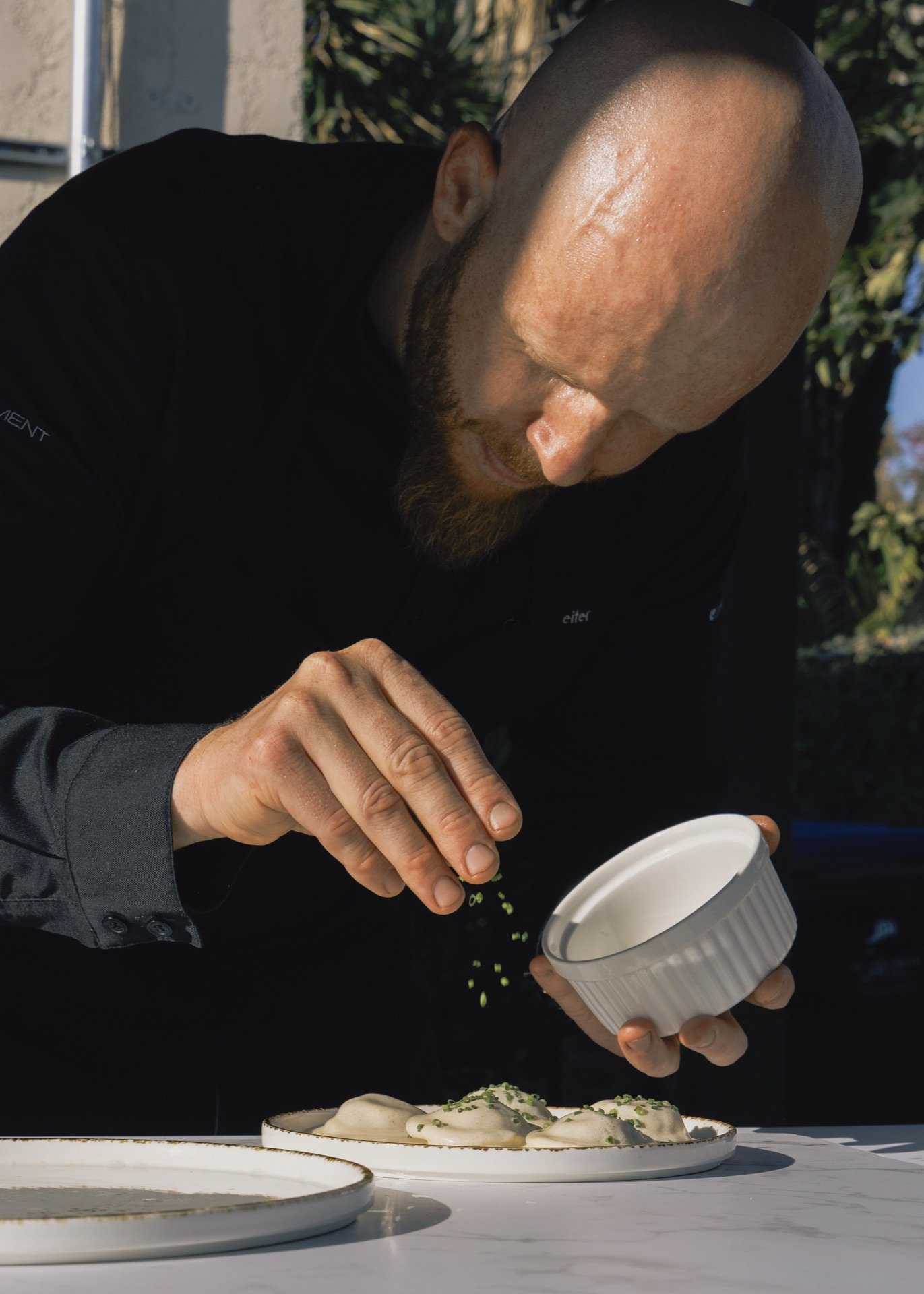 Chef seasoning a dish during service